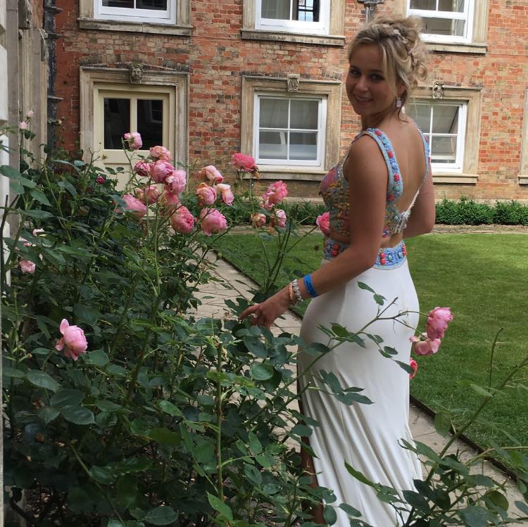 Young prom girl in her sherri hill 2 piece prom dress in a garden on a sunny day