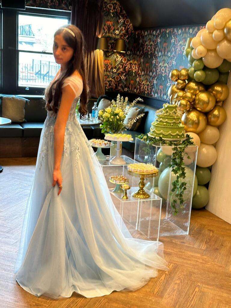Ylona Baby Blue Corset Dress with sweetheart neckline, strapless lace bodice, and flowing tulle skirt, styled for a formal party setting.