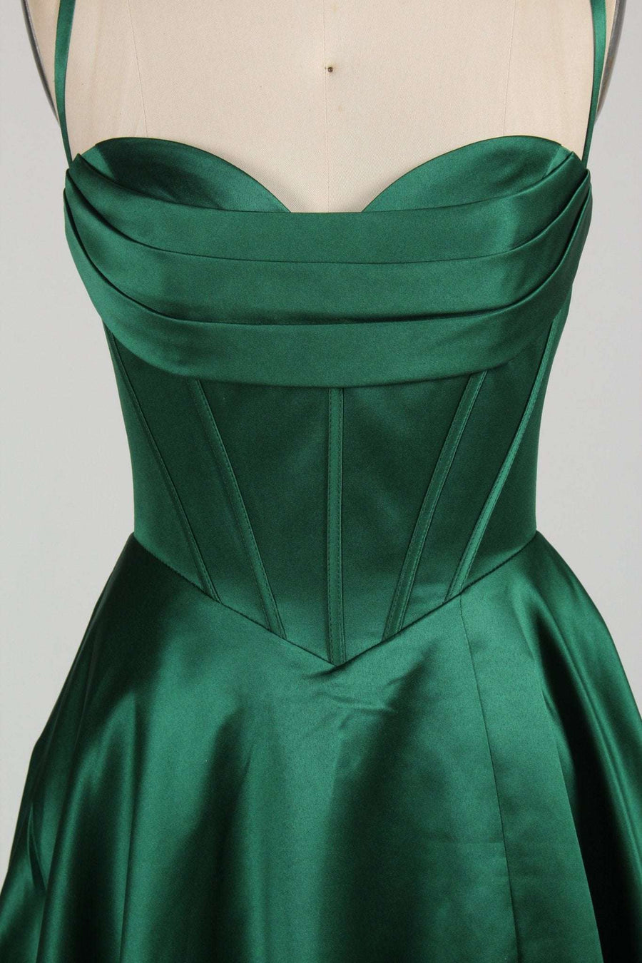 Close-up of Keira emerald green satin ballgown bodice showing structured corset seams and pleated sweetheart neckline.