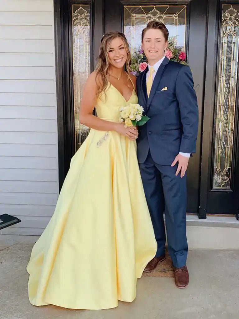 Ava Light Yellow Satin Ballgown with Pockets by Jessica Stuart, featuring a full satin skirt, V-neckline, and open back, perfect for prom or evening wear.