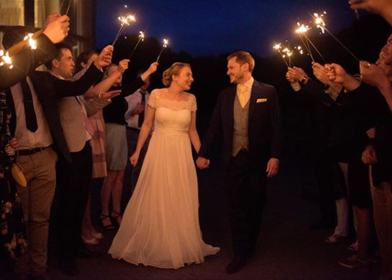 Groom in Sherbet Lemon Wedding Tie walking with bride under sparklers. A standout wedding tie for evening celebrations and formal events.