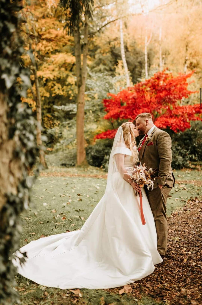 Groom wearing Sienna Wedding Tie in autumn-themed outdoor ceremony, matching the bride's bouquet and fall foliage.