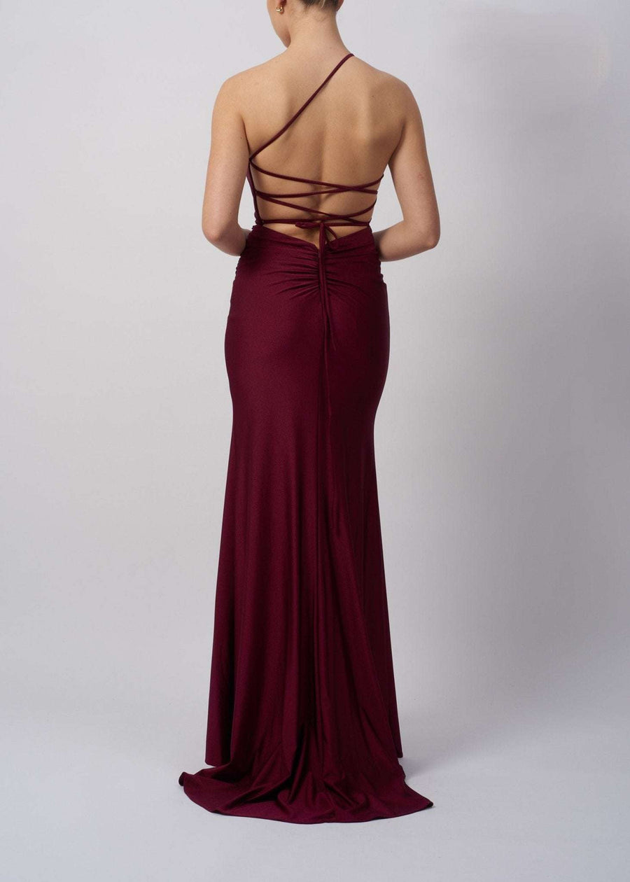 Back view of Navy Tie Back Dress MC12333 in burgundy, featuring daring crisscross straps and a ruched back for a bold gala look.