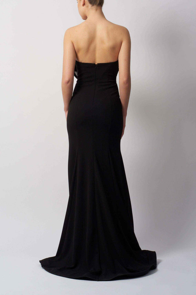Back view of The Bow Jersey Dress by Mascara MC111441, a strapless black evening gown with a fitted silhouette and flowing hemline.