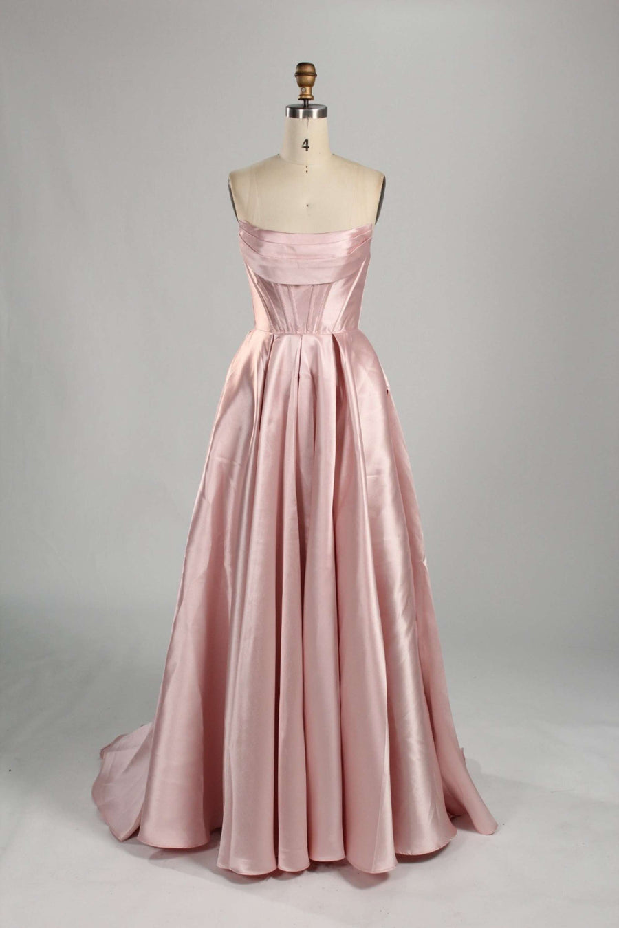 Jessica Stuart light pink satin ballgown with strapless neckline and full skirt, ideal prom dress with hidden pockets for elegance and function.