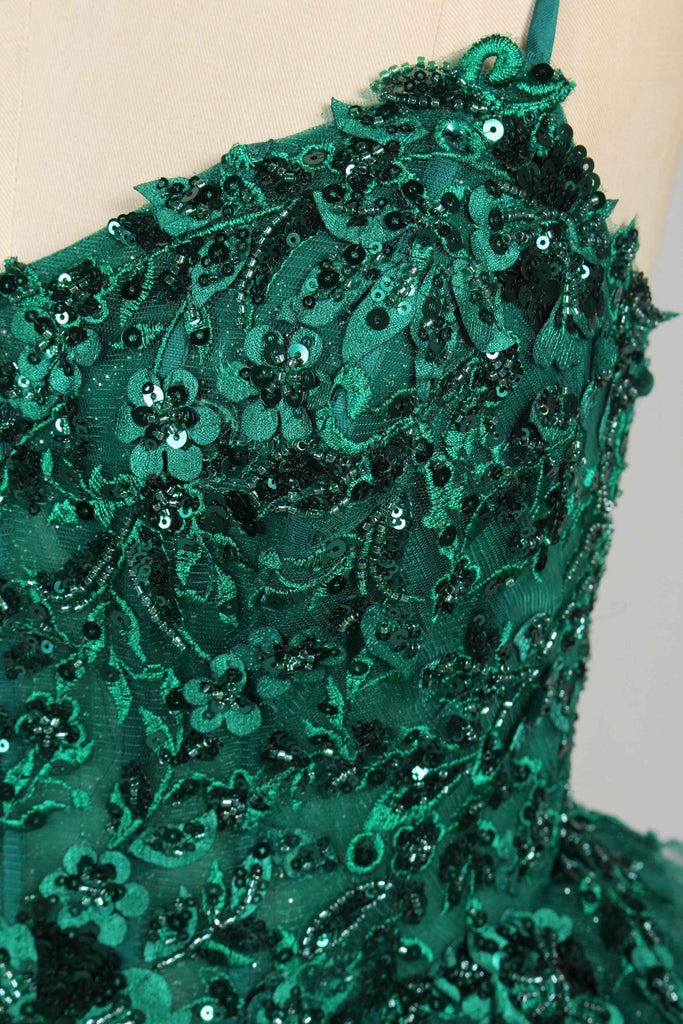 Close-up of Jessica Stuart Hailey Tiered Ruffled Ball Gown 33231 in emerald green with sequin floral lace. Ideal for quinceanera boutiques wholesale.
