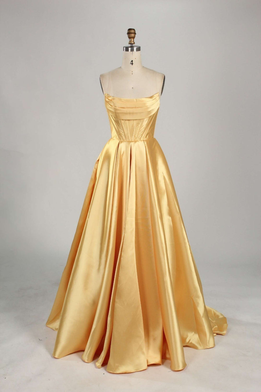 Gold Satin Ball Gown with Pockets Jessica Stuart features a strapless corset bodice and full-length skirt with a sweeping train. Elegant evening dress ideal for prom or red carpet events.