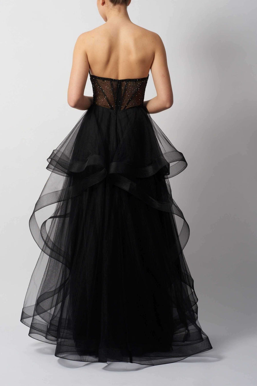 Back view of Double Tulle Mascara MC29514 - Red Collection black strapless dress featuring sheer beaded corset and voluminous layered tulle train.