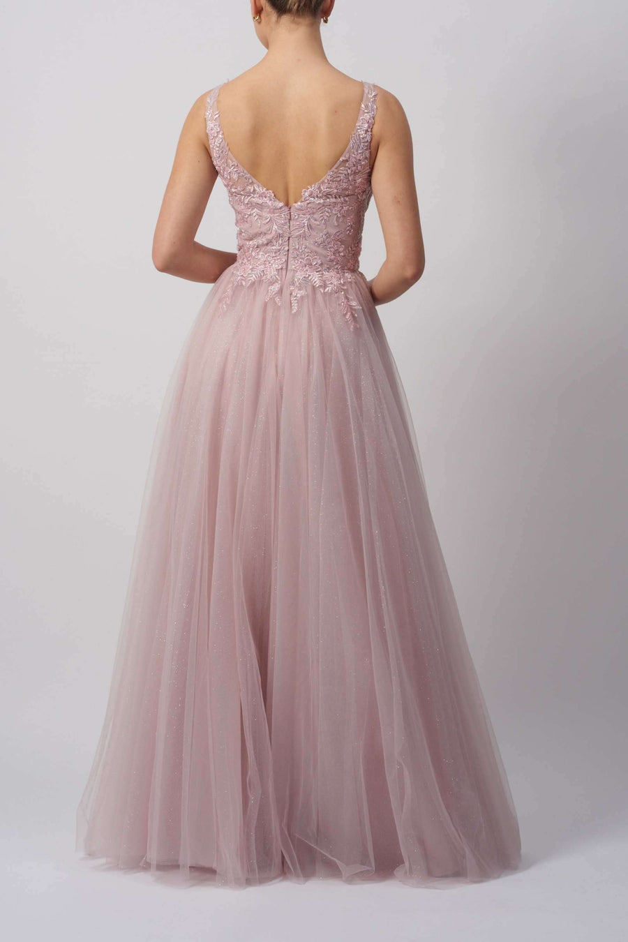 Back view of Mascara Gown MC11346 in blush pink showcases floral embroidery, deep V-back, and layered tulle skirt for formal occasions.
