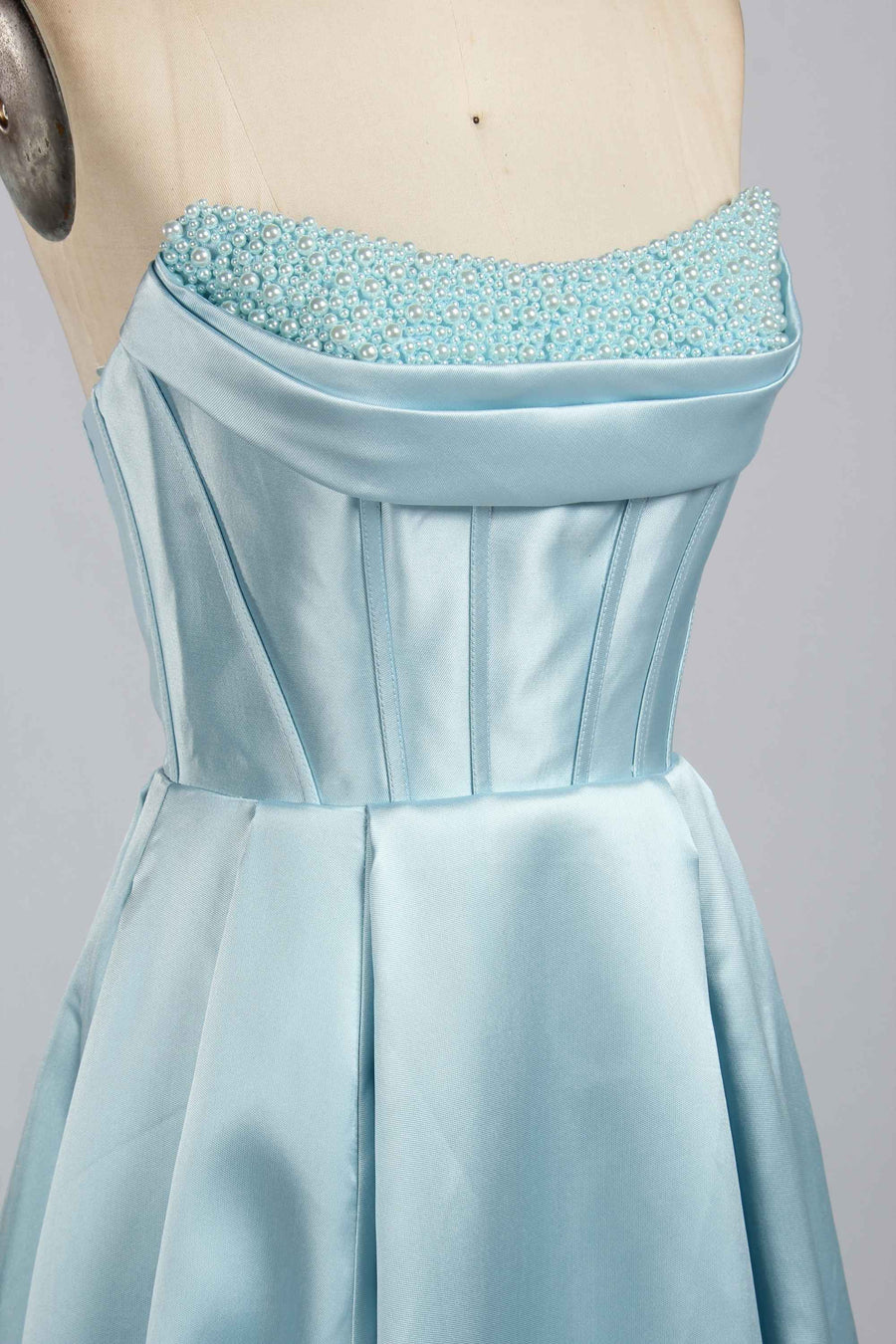 Close-up of Jessica Stuart Light Blue Pearl Strapless Evening Gown 33219B showcasing pearl-embellished bodice and structured satin detailing.