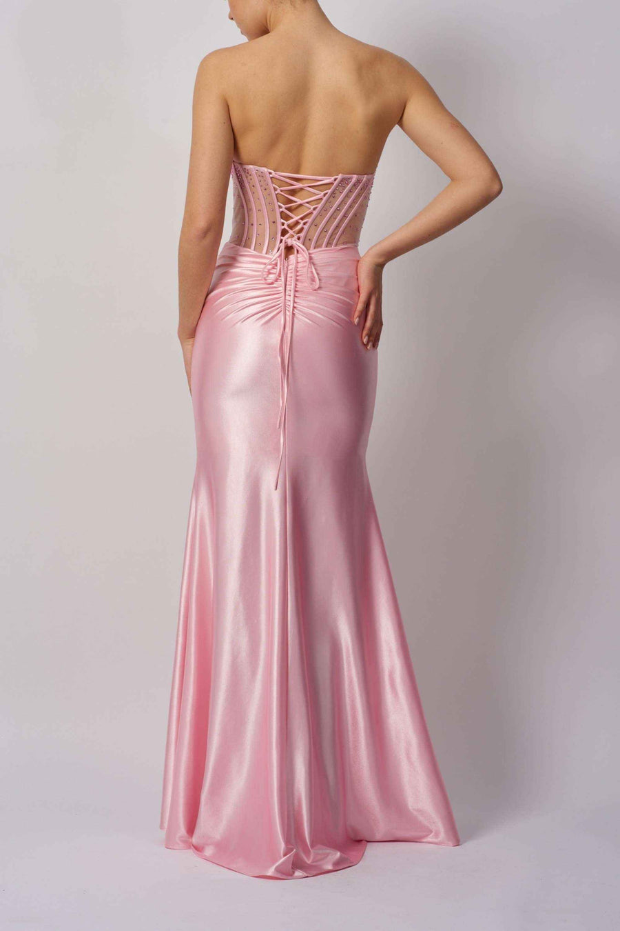 Back view of Mascara MC113423 pink beaded bust gown featuring lace-up corset detail and flowing satin mermaid skirt.