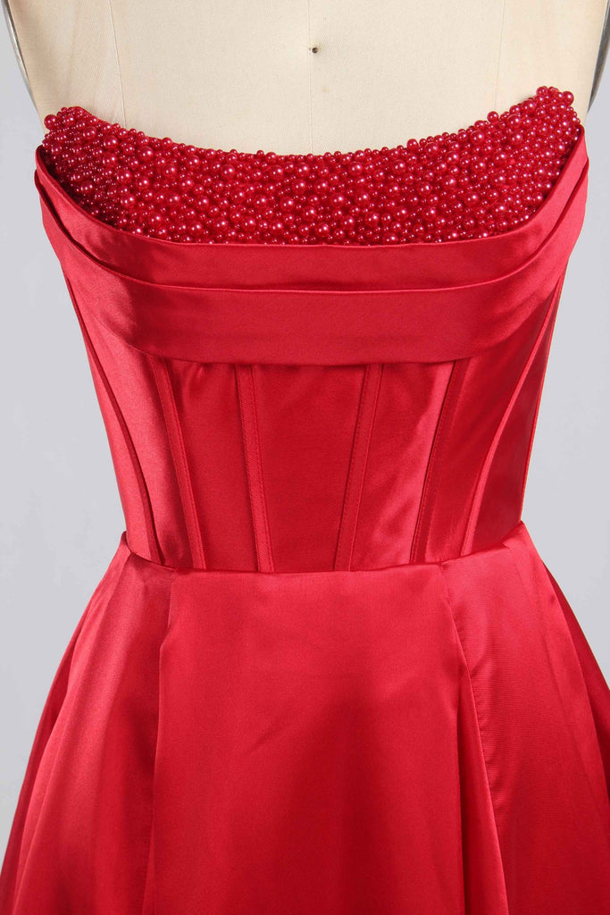 Close-up of Jessica Stuart Red Pearl Evening Gown bodice featuring intricate red pearl detailing and structured satin corset design.