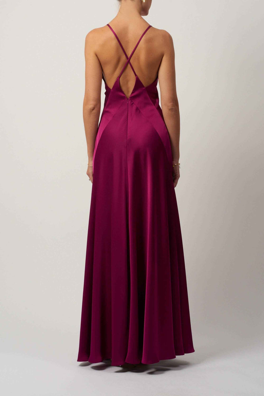 Back view of Mascara London MC122038 prom dress in satin with criss-cross straps and flowing skirt, shown in a vibrant magenta color.