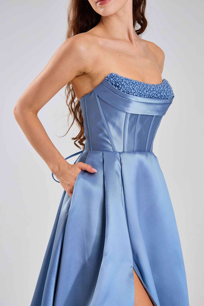 Jessica Stuart Steele Blue Pearl Evening Gown 33219B featuring a satin corset bodice with pearl embellishments and a high-slit pleated skirt.