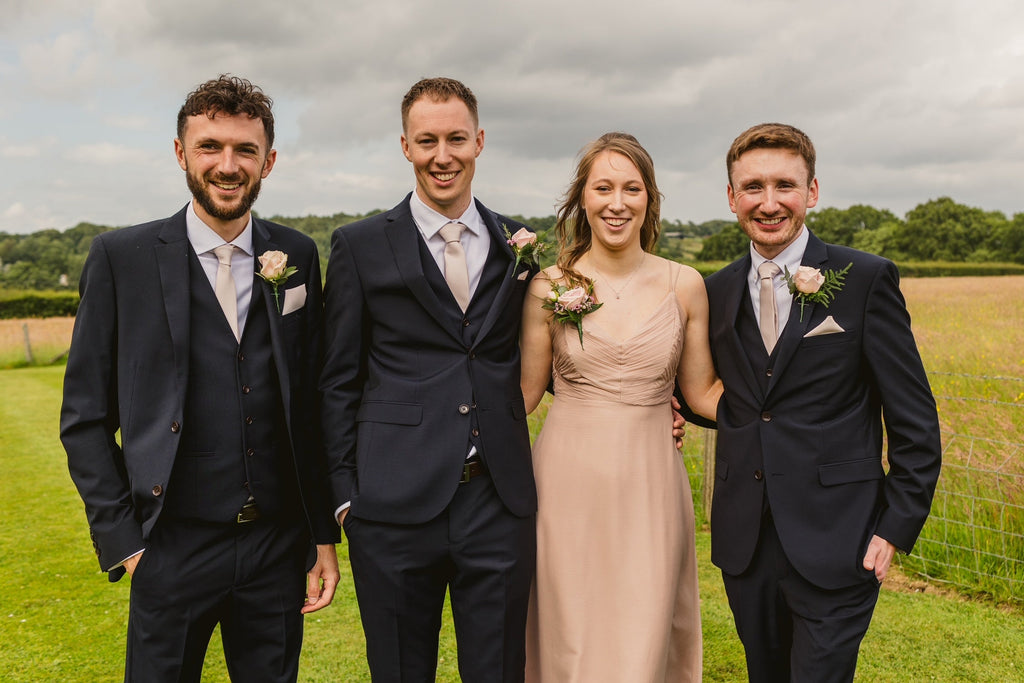 Groomsmen wearing Wedding Tie - Blush Pink Tie paired with navy suits, showcasing coordinated wedding attire in an outdoor setting.