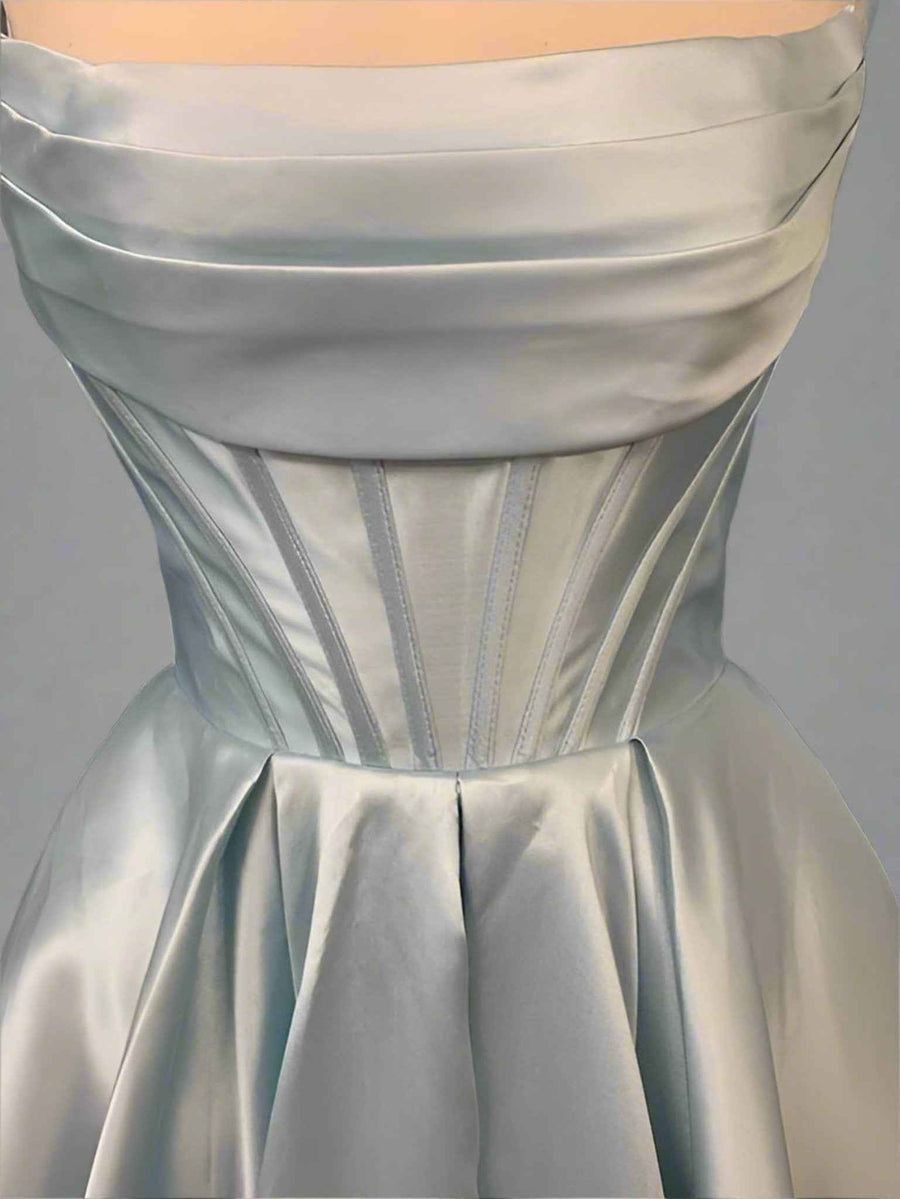 Carmen Ball Gown in light blue satin featuring a strapless neckline, structured bodice with pleats, and elegant gathered skirt. Ideal for prom or red carpet.