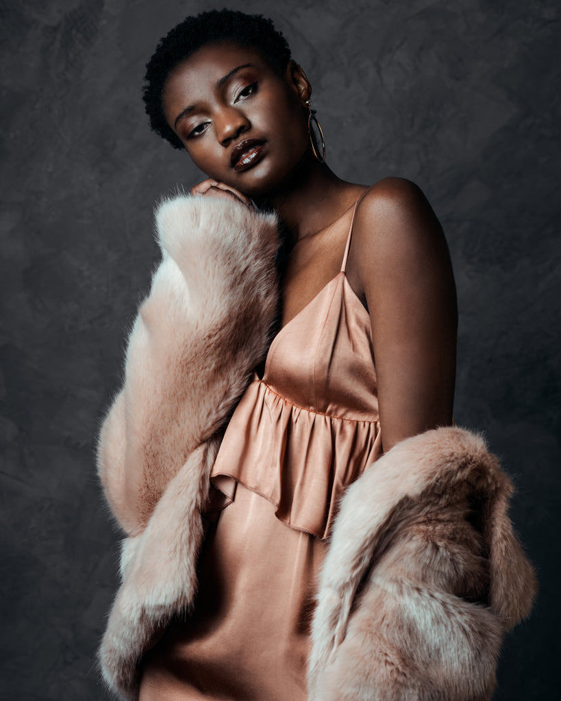 model in pink dress and faux fur coat