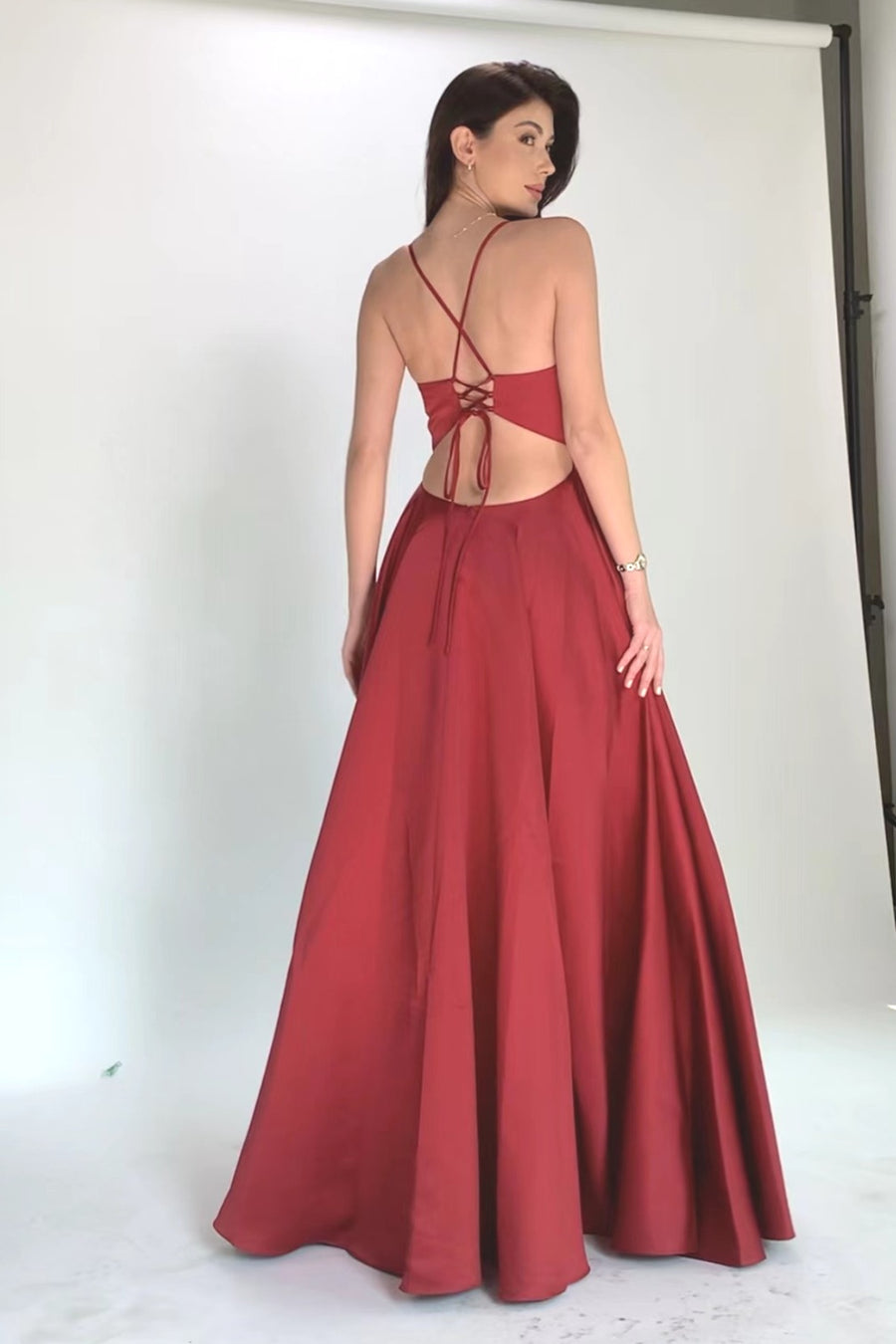 Back view of Imogen Dress featuring open back with tie-back design and full satin skirt in rich wine color.