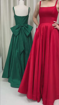 Video of a lady wearing a Red ball gown with pockets and big bow. Same dress in green at the background