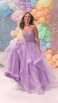 Young woman in a lavender tulle prom gown with lace bodice and spaghetti straps, dancing in front of pastel balloon backdrop