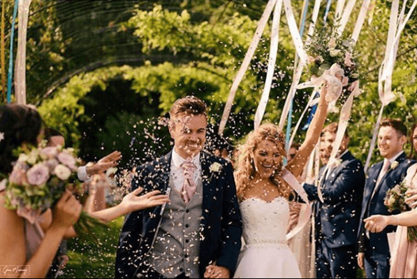 Groom wearing Suede Pink Wedding Cravat at outdoor ceremony, matching bridal party theme. Stylish pink cravat for groomsmen accessories.
