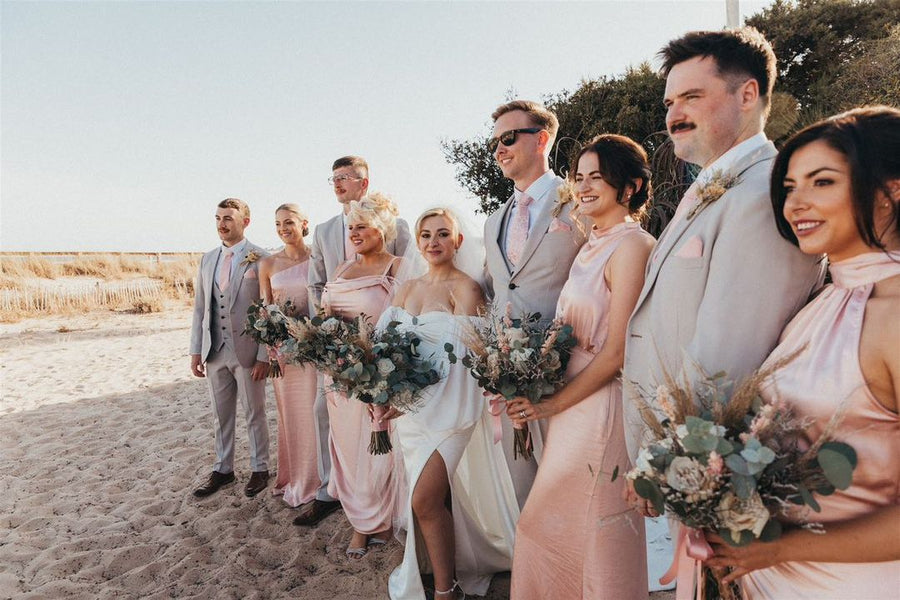 Beach wedding party with groomsmen in Vintage Rose Wedding Ties and bridesmaids in blush dresses, creating a cohesive pastel theme.