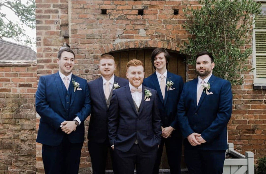 Groom and groomsmen wearing Vintage Rose Bow Ties with navy suits, showcasing coordinated wedding attire for a stylish ceremony look.