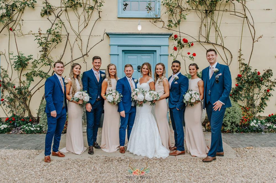 Bride and groom with wedding party in blush and navy attire, featuring Vintage Rose Wedding Ties for a soft romantic color palette.
