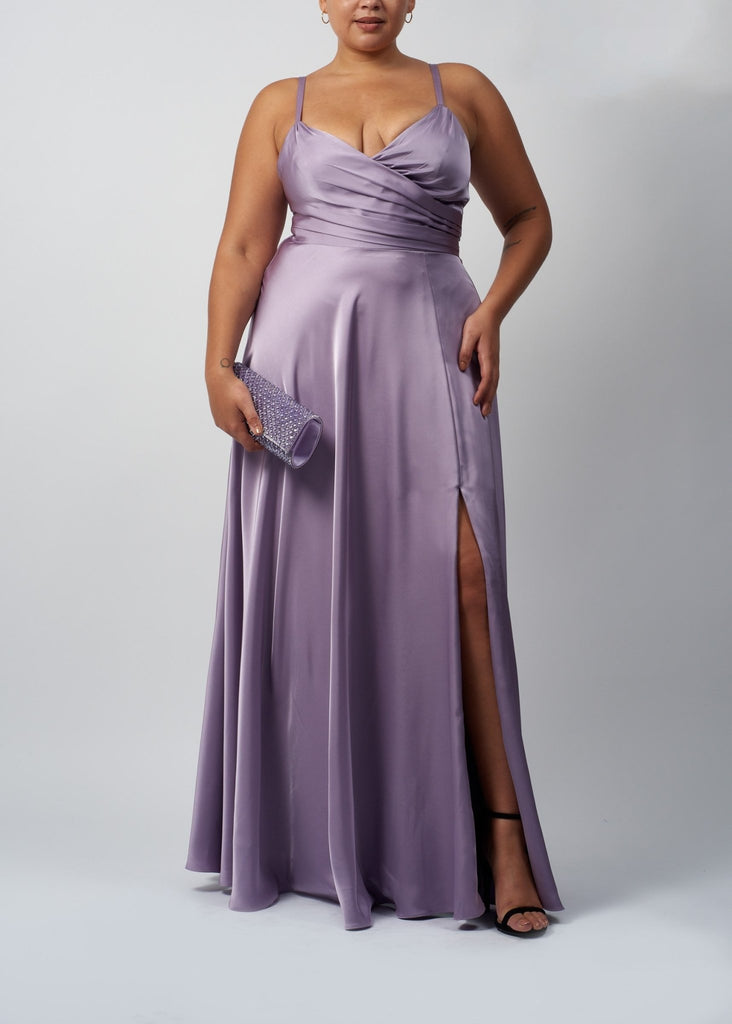 plus sized lady wearing a lavender satin ballgown with wrap bodice and high split